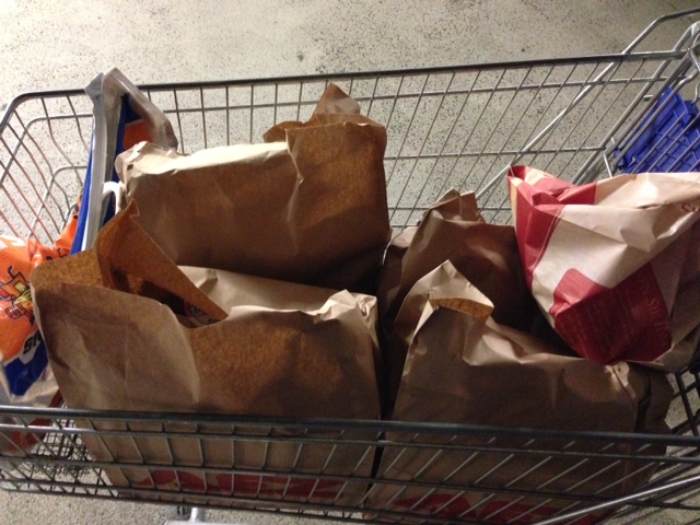 Die Waren kommen in brauen Tüten in den Einkaufswagen zurück.