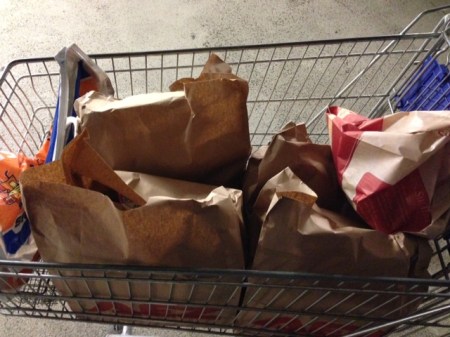 Die Waren kommen in brauen Tüten in den Einkaufswagen zurück.