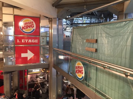Mit einer Plane ist das Burger Restaurant am Hauptbahnhof München verhängt.
