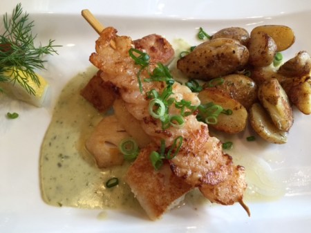 Fischteller mit drei verschiedenen Fischfilets und Garnelenspieß