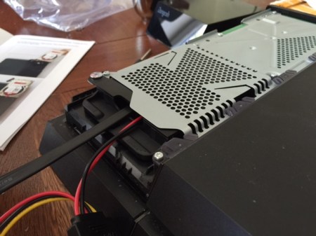 Die Abdeckung der Game Bar-Verkleidung aufsetzen und die Festplattenanschlusskabel durch die Öffnung ziehen.