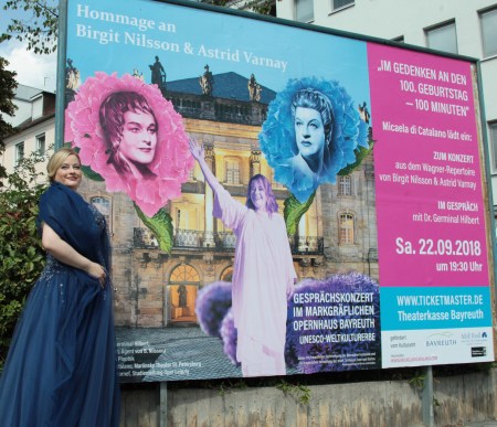 Micaela di Catalano vor dem Veranstaltungsplakat.