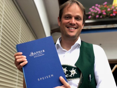 Hotelier Armin Gross mit der Speisekarte des Saphir. 